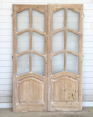 Pair of wooden doors with glass panels on a white background