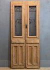 Wooden double door with metal grille on a gray background