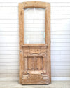 Vintage wooden door with glass panel against a white paneled wall