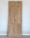 Pair of wooden doors against a white paneled wall
